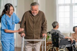 Staff assist older residents in a bright common room during a planned emergency preparedness drill.