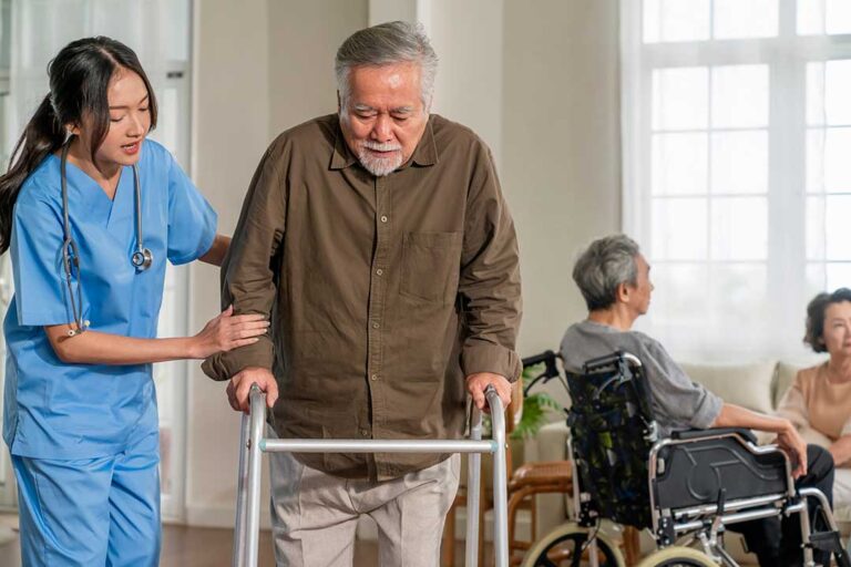Staff assist older residents in a bright common room during a planned emergency preparedness drill.