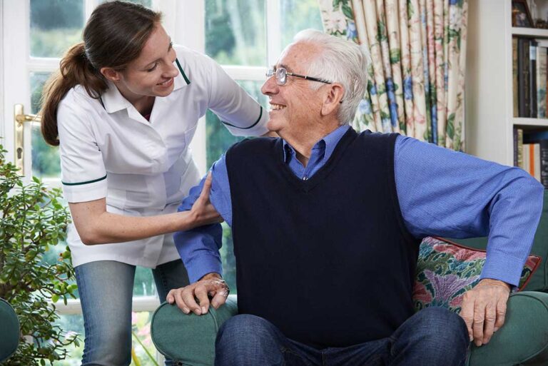 Older adult and family member reviewing a daily care checklist at a kitchen table.
